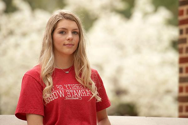 Close up of student on campus with blooming flowers in the background